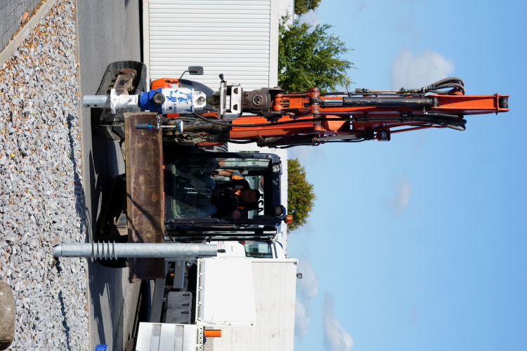 Foto mit Bagger nach dem das Schraubfundament im Erdreich eingedreht worden ist.